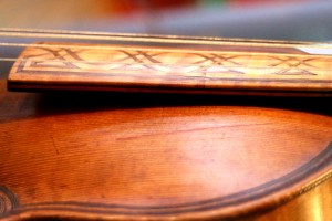 The join between the old and 'mordern' fingerboard. Some of the marquetry has fallen out