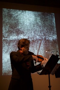 Peter Sheppard Skaerved with his drawing of the Thames. playing David Riebe's piece inspired by the art. Photo Neil Heyde